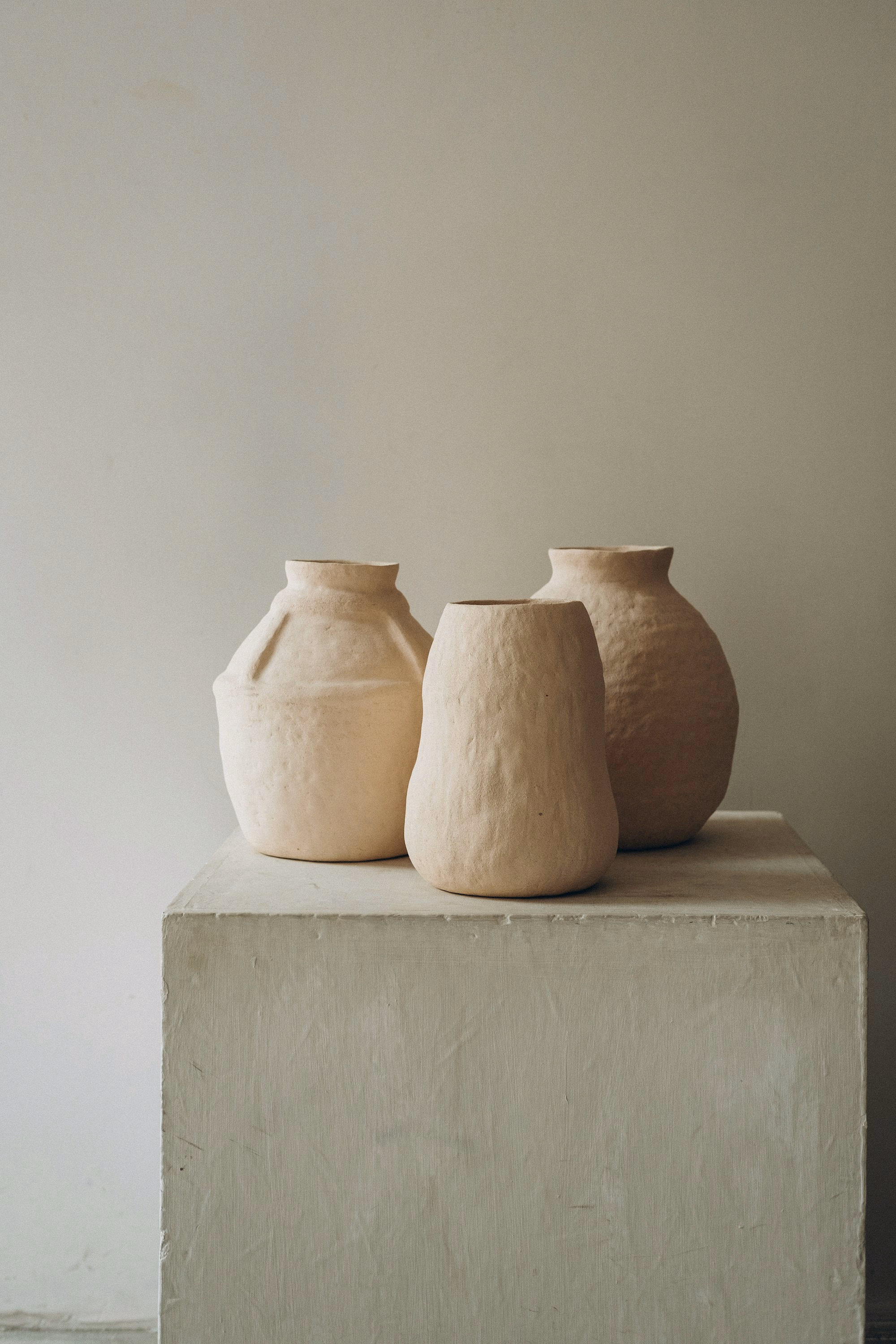 Three clay vases on a pedestal